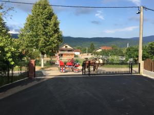 un carruaje tirado por caballos estacionado frente a una casa en Amina River Apartment, en Bihać