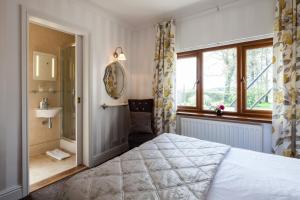 ein Schlafzimmer mit einem Bett, einem Waschbecken und einem Fenster in der Unterkunft Langdon Farm Guest House in Saundersfoot