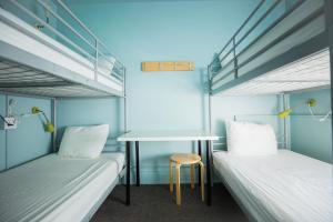 a bedroom with two beds and a desk at HI - Seattle Hostel at the American Hotel in Seattle