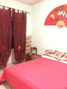 a bedroom with a pink bed and red curtains at Casa Olbia 2 in Olbia