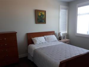 sypialnia z łóżkiem, komodą i oknem w obiekcie 风语海景 w mieście Nanaimo