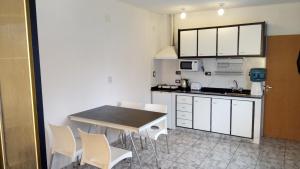 a kitchen with white cabinets and a table and chairs at Casa Central in Roldán