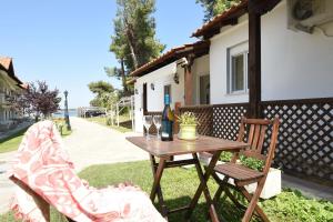 a table and two chairs with a bottle of wine at Haus Platanos Apartments & Bungalows by the Sea in Vourvourou
