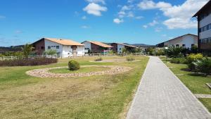 a walkway through a park with houses in the background at Flat no Canarius Residence - Gravatá in Gravatá