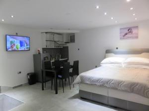 a bedroom with a bed and a dining room at Apartman in Cres