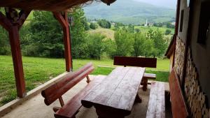einen Holztisch und eine Bank auf einer Veranda mit Aussicht in der Unterkunft Holiday Home Cakic in Novi Travnik