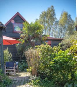 a garden with a palm tree and a house at Twin Gullies in Akaroa