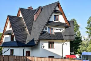 une maison avec un toit noir dans l'établissement Willa u Słodkiego, à Zakopane