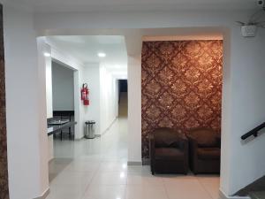 a hallway with two chairs and a wall with a wall at Hotel Rio Branco in São Paulo