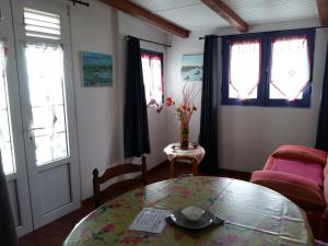 a living room with a glass table and windows at Les Pimentiers de Papaye in Saint-Claude