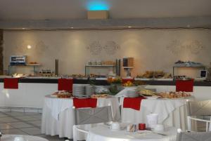 a buffet line with two tables with plates of food at UNAHOTELS Club Hotel Ancora in Stintino