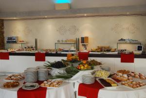 a buffet of food on two tables in a room at UNAHOTELS Club Hotel Ancora in Stintino