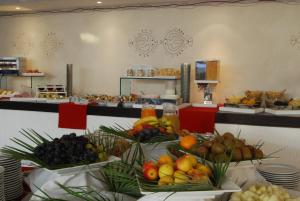 a bunch of fruits on plates on a table at UNAHOTELS Club Hotel Ancora in Stintino
