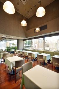 a restaurant with tables and chairs and large windows at Premier Hotel Cabin Shinjuku in Tokyo