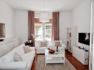 a white living room with white couches and a tv at Business Appartements "Villa Münz" in Pula