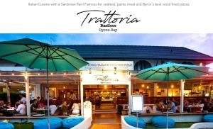 - un restaurant avec des tables et des parasols dans l'établissement Bay Beach Motel, à Byron Bay