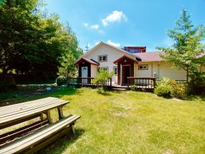 a house with a bench in front of a yard at Nadeuri Pension in Pyeongchang 