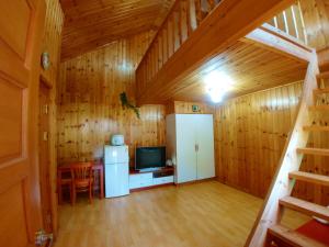 a large room with a kitchen and a refrigerator and a television at Nadeuri Pension in Pyeongchang 