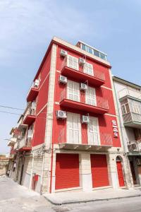 czerwony budynek z czerwonymi drzwiami na ulicy w obiekcie La dimora del monsignore w mieście Licata