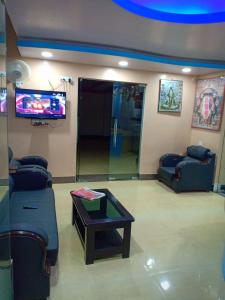a living room with two couches and a tv at Hotel Sunaina International in Gaya