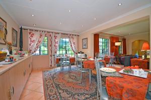 une cuisine et un salon avec une table et des chaises dans l'établissement Cherry Tree Cottage B&B Linden, à Johannesbourg