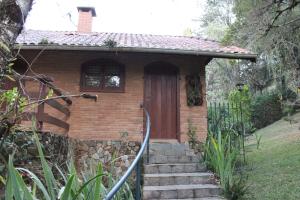 een stenen huis met een trap naar een deur bij Chales Chez Nous in Monte Verde