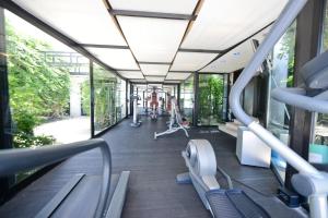 - une salle de sport avec bancs et vélos elliptiques dans un bâtiment dans l'établissement Grand Hotel Masseria Santa Lucia, à Ostuni