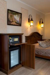 um quarto com uma cama e uma televisão num quarto em Hotel Incanto em Vladivostok