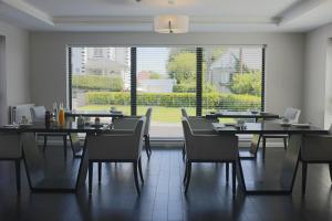 a dining room with tables and chairs and a large window at Glass Island Ballycastle in Ballycastle