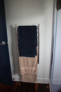 a towel is hanging on a rack in a bathroom at Sea Urchin Cottage in Miranda
