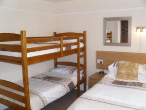 a bedroom with two bunk beds and a mirror at Seaforth Guest House - Pleasure Beach in Blackpool