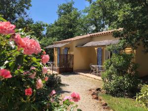 uma casa com um jardim e rosas em frente em Le Clos des Cigales em Roussillon