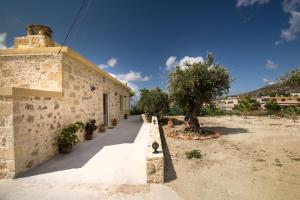 un edificio in pietra con un albero di fronte di Margarita's Stone House a Plátanos