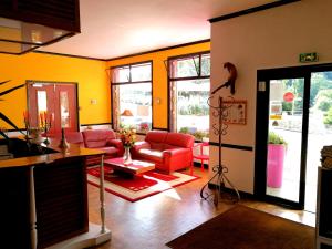 a living room with red furniture and yellow walls at Le relais du Haut Limousin in Eymoutiers