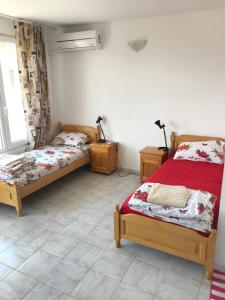 a bedroom with two beds and two lamps in it at Guesthouse in Chernomorets next to Gradina and Sozopol in Chernomorets
