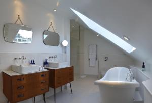 a white bathroom with two sinks and a tub and a sink at Trevose Harbour House in St Ives +37 photos