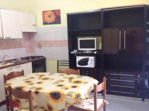a kitchen with a table and a tv on a counter at Casa Olbia 2 in Olbia