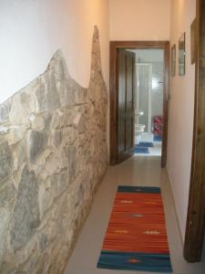 a hallway with a stone wall and a hallway with a rug at Casa Olbia 2 in Olbia