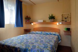 a bedroom with a bed with a blue comforter at Ca' Berton Village in Cavallino-Treporti