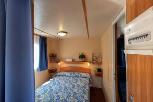 a small bedroom with a bed in a small room at Ca' Berton Village in Cavallino-Treporti