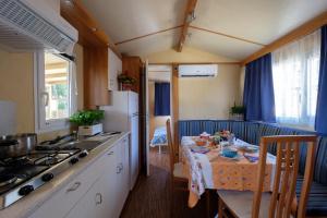 a kitchen with a table and a kitchen with a stove at Ca' Berton Village in Cavallino-Treporti