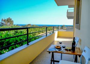 a balcony with a table and glasses of wine at Kiotari Dreams in Kiotari