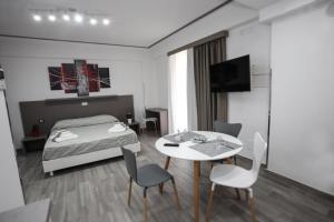 a hotel room with a bed and a table and chairs at Le colombe di Venere in Trapani