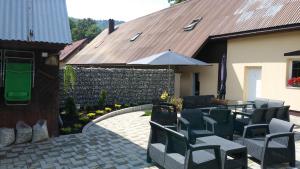 a patio with chairs and a table and an umbrella at Penzión U nás in Oravský Podzámok