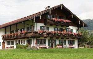 ein Haus mit Blumenkästen auf dem Balkon in der Unterkunft Gästehaus-Bauernhof Buchwieser in Unterammergau