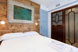 a bedroom with a white bed and a wooden wall at Gran H La Marina in Altea