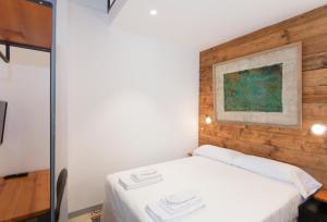 a bedroom with a white bed with a wooden wall at Gran H La Marina in Altea