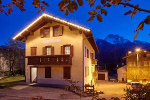 Casa Cadore في Lozzo Cadore: منزل أبيض مع أضواء عليه في الليل