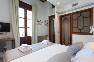 a bedroom with a white bed with towels on it at Gran H La Marina in Altea