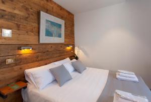 a bedroom with a white bed with a wooden wall at Gran H La Marina in Altea